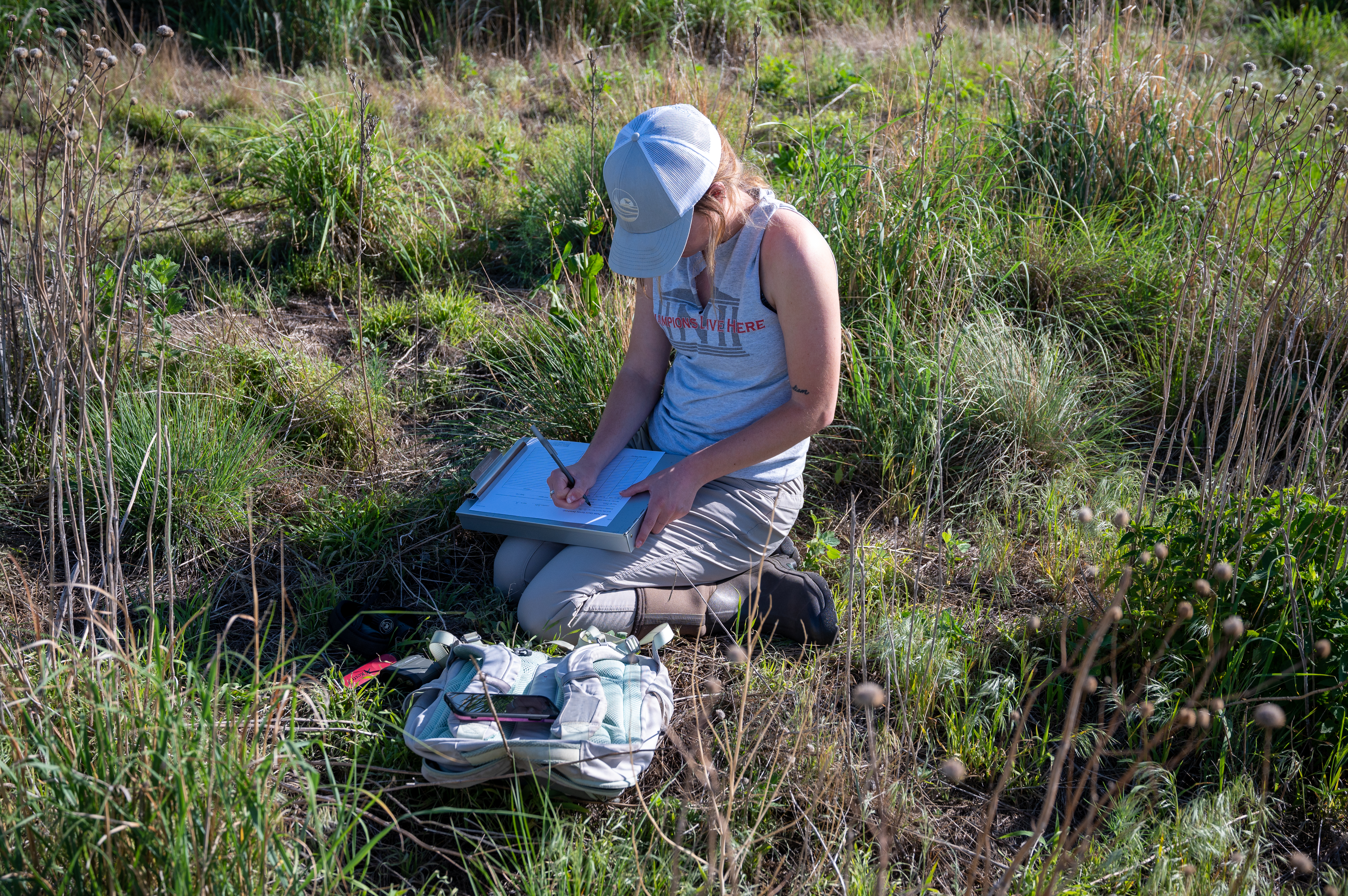 PhD student Grace Schuster fills out data forms in the field