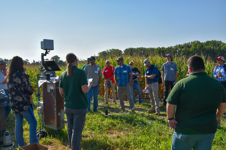 Field day participants listen to a presentation about prairie strips while in the field