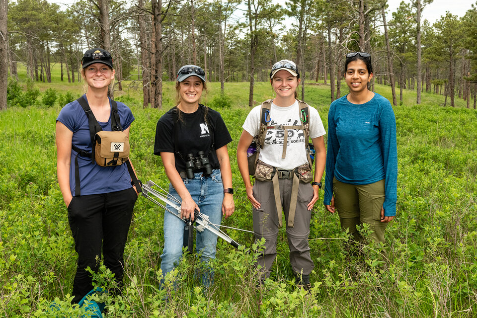 Image of Stephanie Roscoe (field tech), Jade Wawers (graduate student), Catrina Johnson (field tech), and Surya Deepika Garugu (graduate student) standing outdoors while doing field work